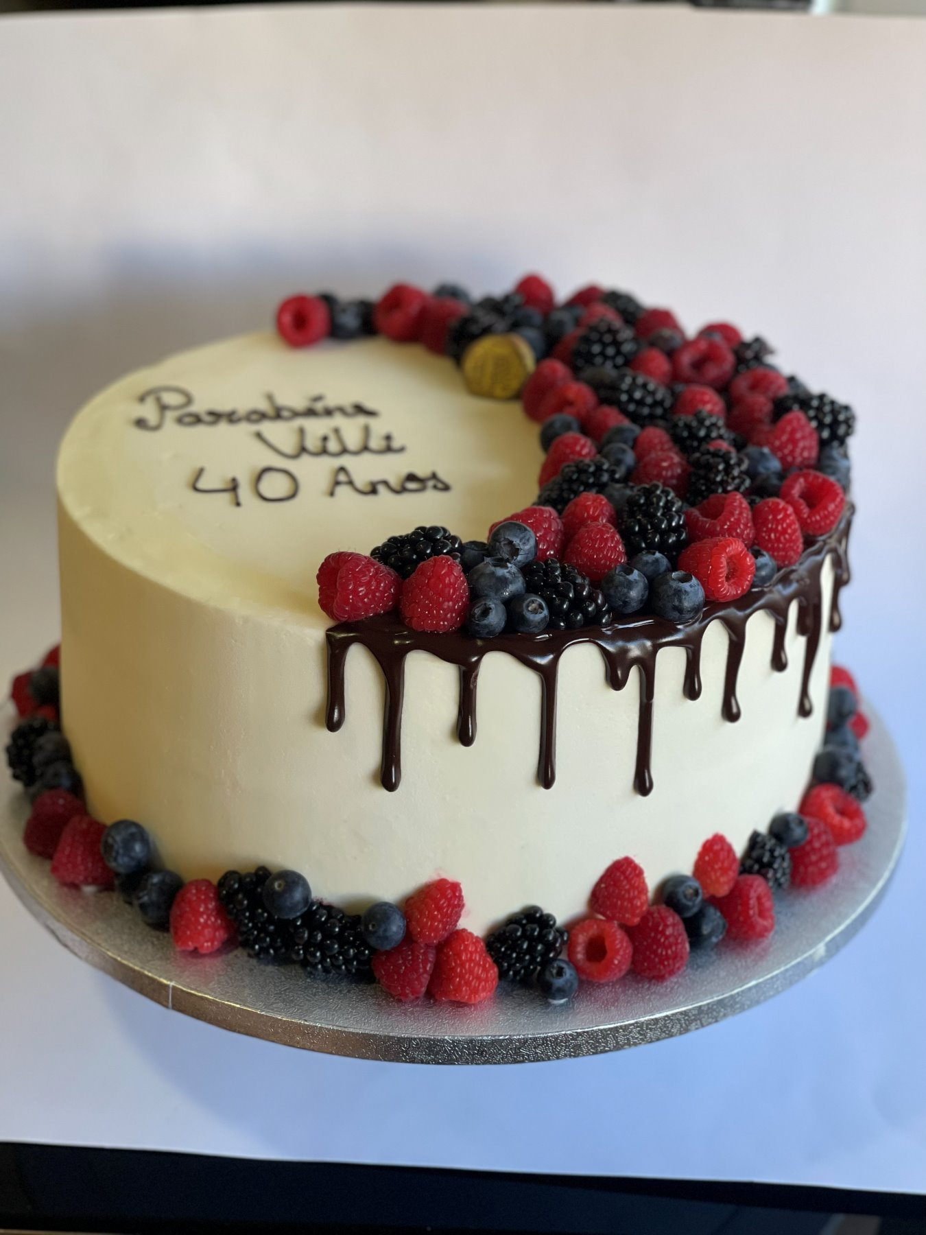 Bolo branco com drip de chocolate e coroa de frutos vermelhos frescos produzido pela Pali Cakes