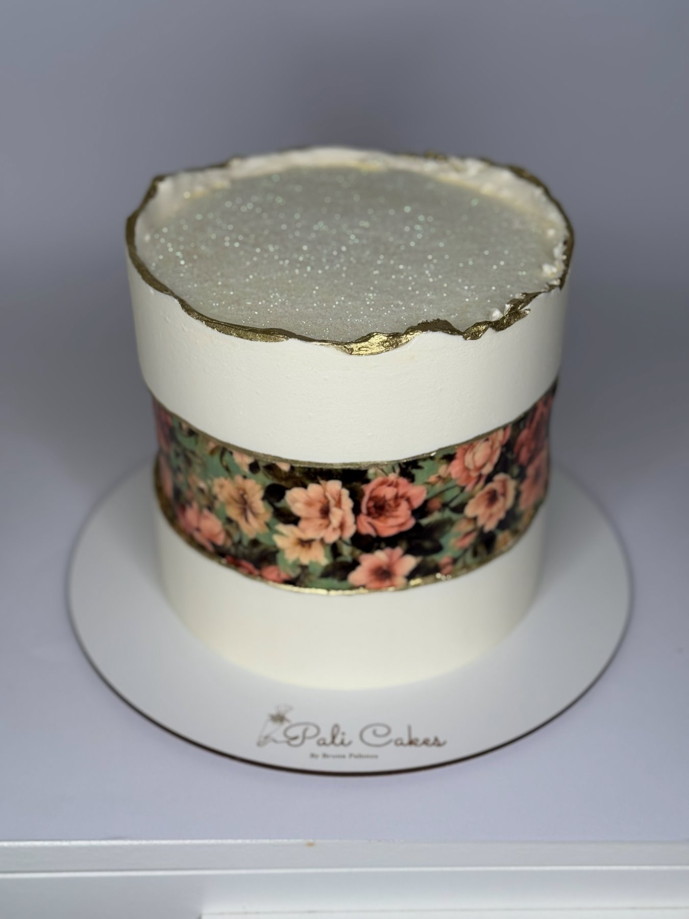Bolo com padrão floral vintage, borda dourada e topo brilhante em efeito geode produzido pela Pali Cakes