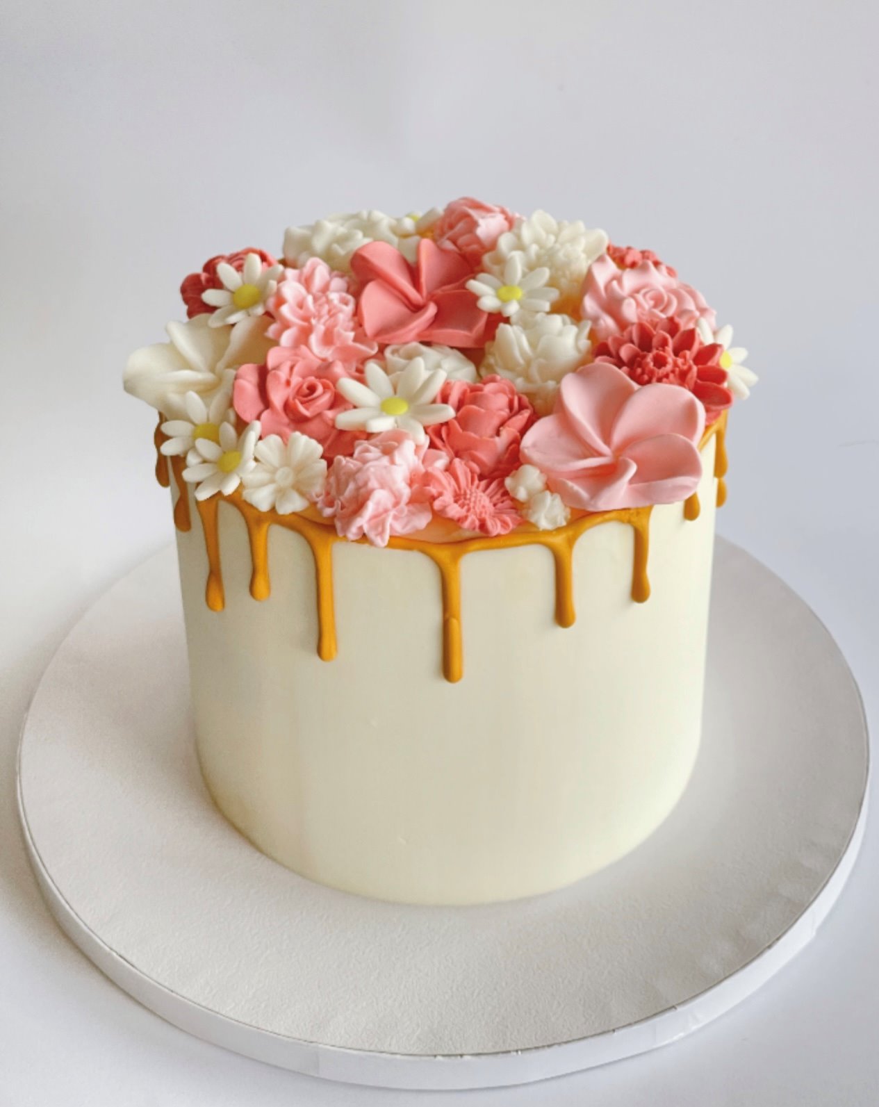 Bolo branco com flores em pasta de açúcar coral e drip dourado produzido pela Pali Cakes