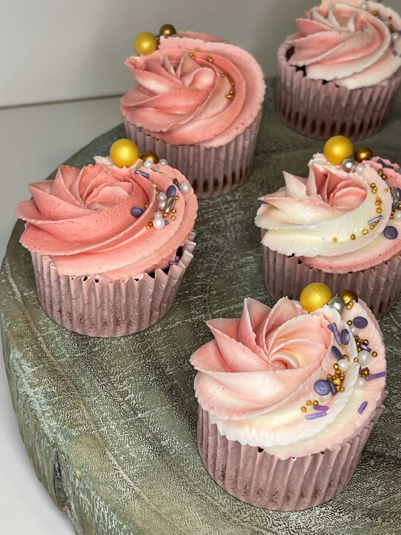 Cupcakes com cobertura em roseta rosa e dourada produzidos pela Pali Cakes